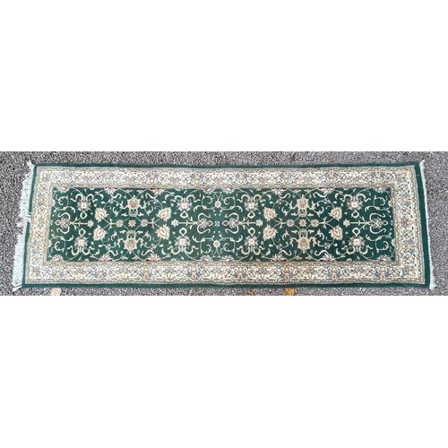 156 - WOOLEN PATTERENED CARPET RUNNER ON GREEN GROUND 245cm x 80cm