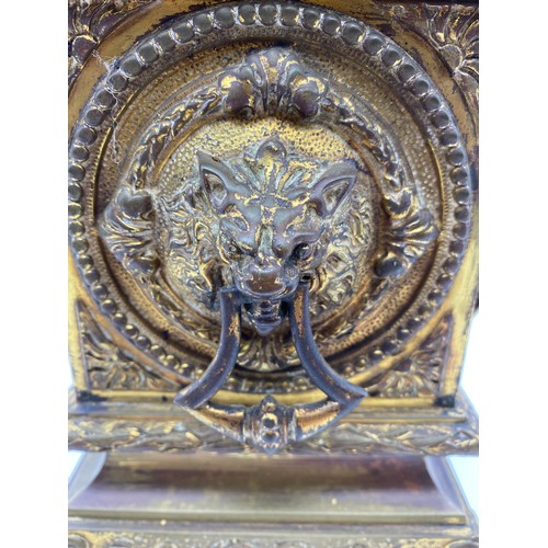 595 - 19TH CENTURY GILT METAL CASED MANTLE CLOCK WITH LIONS MASK HANDLES, DRUM MOVEMENT GLASS A/F