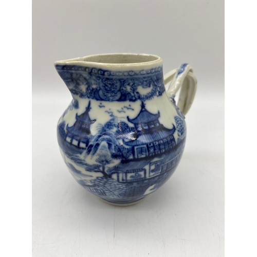 686 - 18TH CENTURY BLUE AND WHITE PAGODA PATTERNED JUG WITH ENTWINED STRAP HANDLE