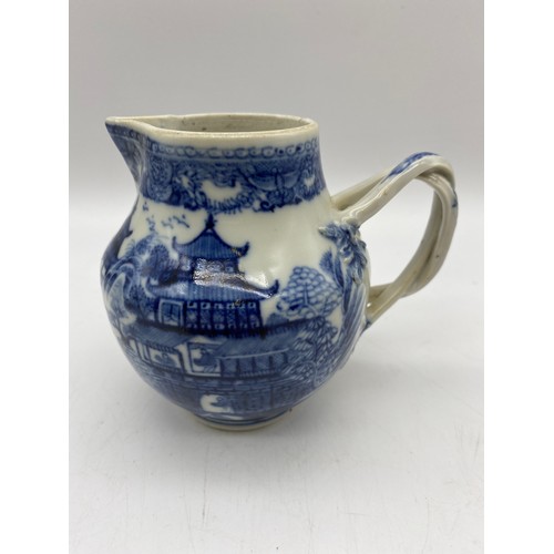 686 - 18TH CENTURY BLUE AND WHITE PAGODA PATTERNED JUG WITH ENTWINED STRAP HANDLE