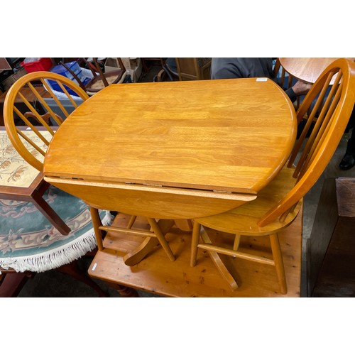 81 - PINE AND BEECH DROP FLAP PEDESTAL KITCHEN TABLE AND FOUR SPINDLE BACK CHAIRS