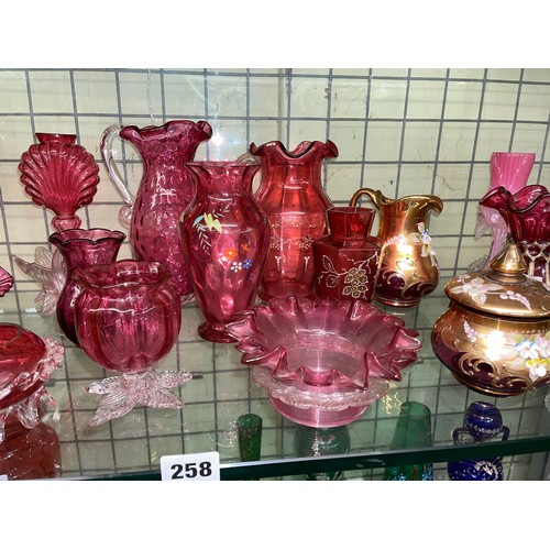 258 - SHELF OF CRANBERRY AND RUBY GLASSWARE INCLUDING CRIMPED EDGE BOWLS, JUGS, AND SILVER OVERLAY SMALL V... 