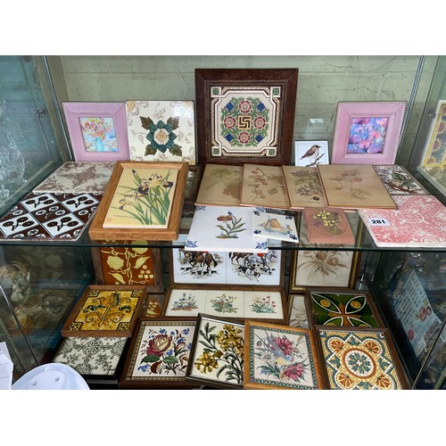 281 - TWO SHELVES OF DECORATIVE CERAMIC TILES AND TILE TRIVETS DECORATED WITH MAINLY FLOWERS AND ANIMALS