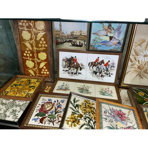 281 - TWO SHELVES OF DECORATIVE CERAMIC TILES AND TILE TRIVETS DECORATED WITH MAINLY FLOWERS AND ANIMALS