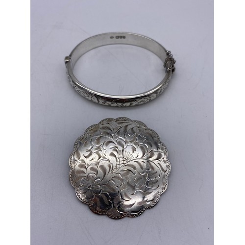 394 - STERLING SILVER ENGRAVED SCALLOPED BROOCH, SILVER ENGRAVED BANGLE WITH SAFETY CHAIN