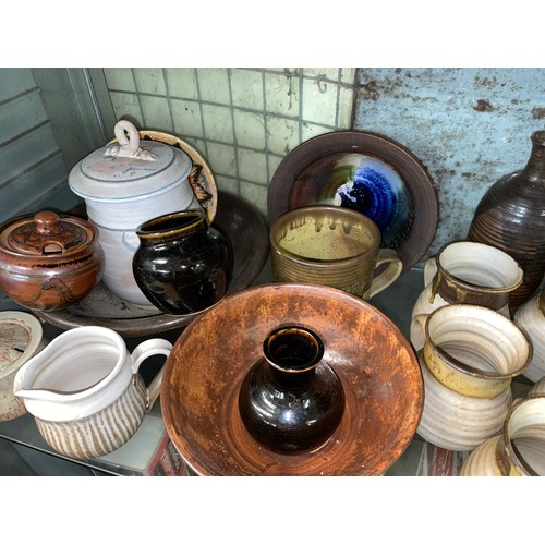 228 - SHELF OF STUDIO POTTERY WARE INCLUDING COFFEE CUPS, TEAPOT, AND LIDDED JARS ETC.