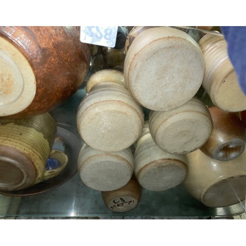 228 - SHELF OF STUDIO POTTERY WARE INCLUDING COFFEE CUPS, TEAPOT, AND LIDDED JARS ETC.