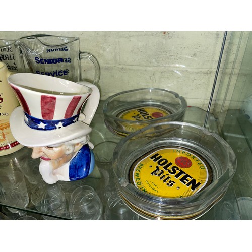 237 - SHELF OF WHISKY ADVERTISING JUGS, TWO GLASS HOLSTEN PILS ASHTRAYS, AND AN UNCLE SAM CHARACTER JUG