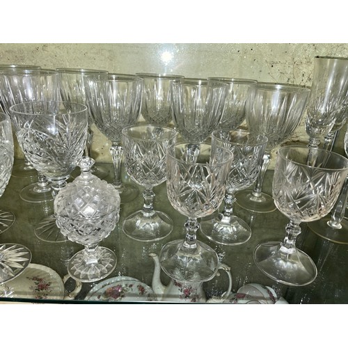 238 - TWO SHELVES OF CUT GLASSWARE INCLUDING CHAMPAGNE FLUTES, GOBLETS, BRANDY BALLOONS AND CLARET JUGS