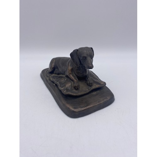 411 - MARY RINSENL BRONZED RECUMBENT DASCHUND ON CUSHION 8CM H