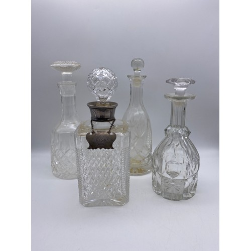 403 - FOUR CUT GLASS DECANTERS, ONE WITH SILVER WHISKY SPIRIT LABEL