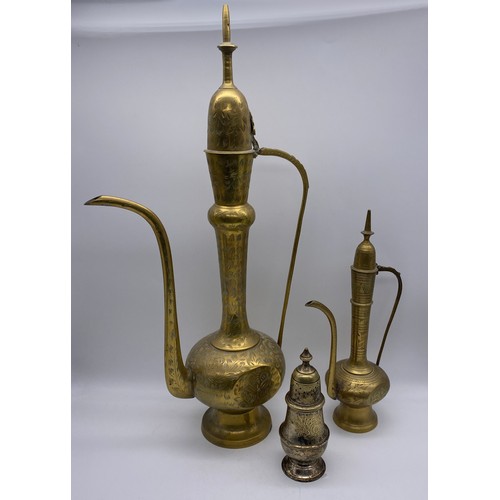 406 - TWO EASTERN BRASS ENGRAVED COFFEE EWERS AND A PLATED SUGAR SIFTER