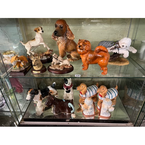 239 - TWO SHELVES OF ASSORTED DOG FIGURES INCLUDING TERRIERS TEAPOT, ALSATIAN, POODLES, ETC