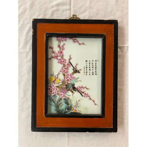 489 - ORIENTAL GLASS PANEL PAINTED WITH BIRDS AMONGST PRUNUS BLOSSOM WITH SCRIPT FRAMED 17CM X 24CM APPROX