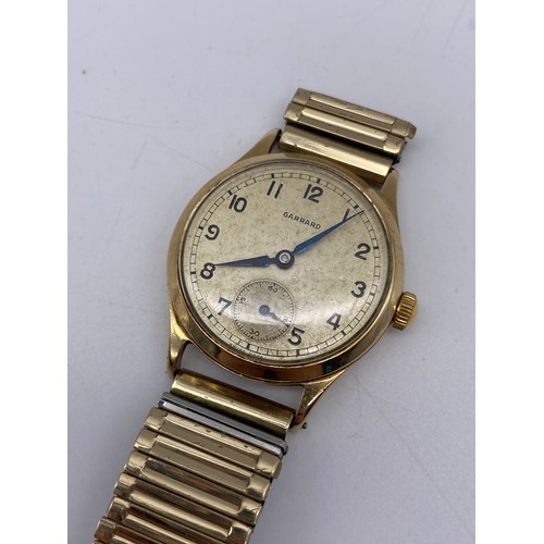 439 - GENTS 9CT GOLD GARRARD PRESENTATION WRIST WATCH ON EXPANDING STRAP AS FOUND