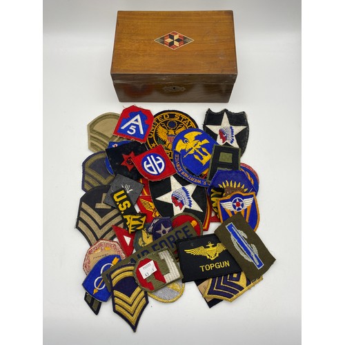 397 - WOODEN BOX OF MILITARY RELATED BADGES