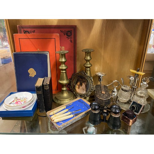 196 - SHELF INCLUDING PAIR OF BRASS CANDLESTICKS, OPERA GLASSES, PLATED CRUET SET, MANICURE SET AND PIN DI... 