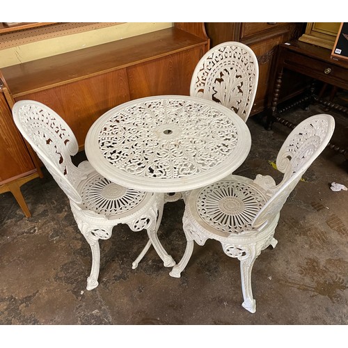 92 - CAST METAL CIRCULAR PATIO TABLE AND THREE FERN BACK CHAIRS