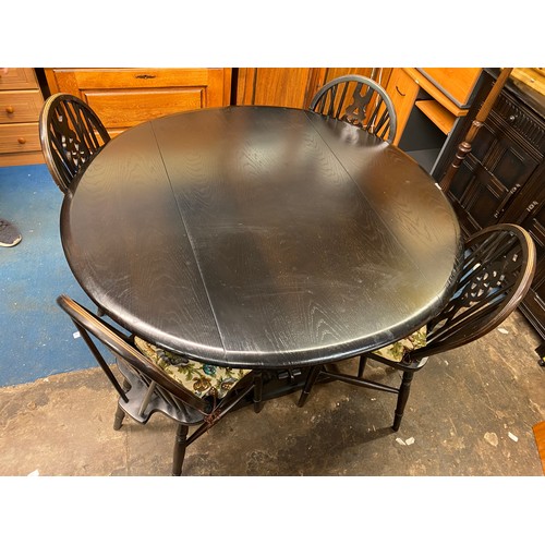 64 - DARK OAK DROP FLAP TABLE AND FOUR WHEEL BACK CHAIRS