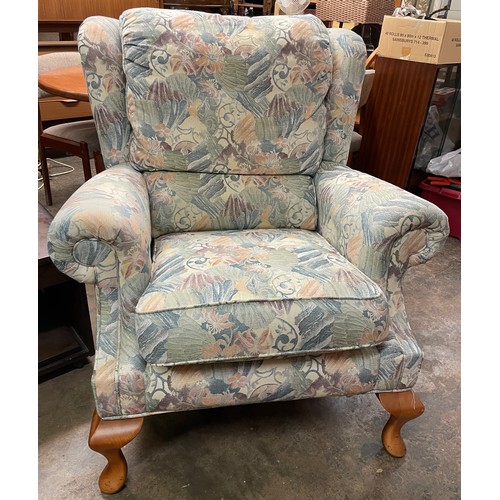 106 - FLORAL FABRIC WING ARMCHAIR ON CABRIOLE LEGS AND MATCHING FOOTSTOOL