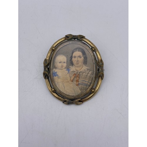 525 - SMALL OVAL PORTRAIT MINIATURE OF LADY AND CHILD IN AN UNMARKED YELLOW METAL ORNATE FRAME WITH PIN BR... 