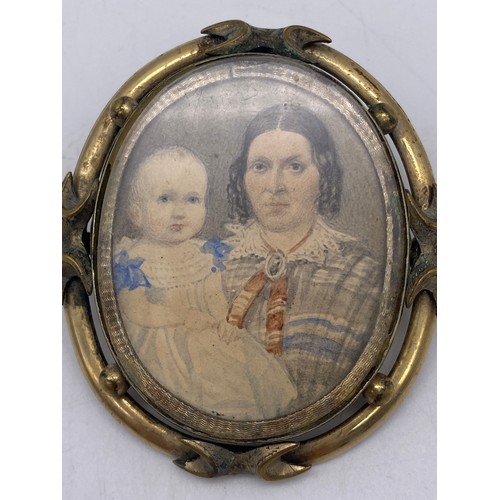 525 - SMALL OVAL PORTRAIT MINIATURE OF LADY AND CHILD IN AN UNMARKED YELLOW METAL ORNATE FRAME WITH PIN BR... 