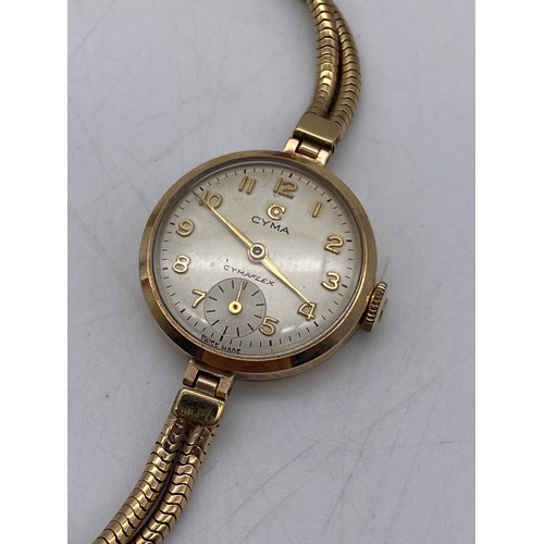 542 - CASED LADIES CYMA ROUND FACED GOLD CASED WRIST WATCH ON TWIN HERRINGBONE STRAP WITH SAFETY CHAIN 11G... 