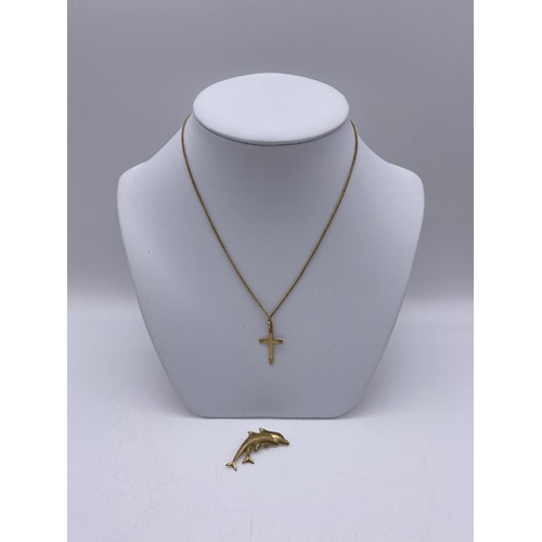 557 - 9CT GOLD CROSS ON ROLLED GOLD CHAIN, 9CT GOLD LEAPING DOLPHIN BROOCH 1.5G APPROX OVERALL