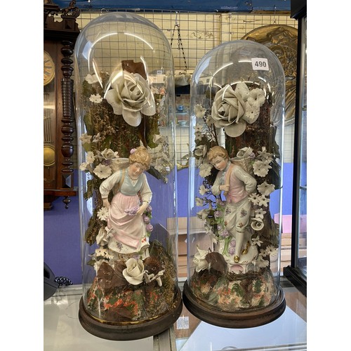 490 - PAIR OF VICTORIAN GERMAN PORCELAIN BOY AND GIRL FIGURE IN FLORAL SETTING UNDER GLASS DOMES