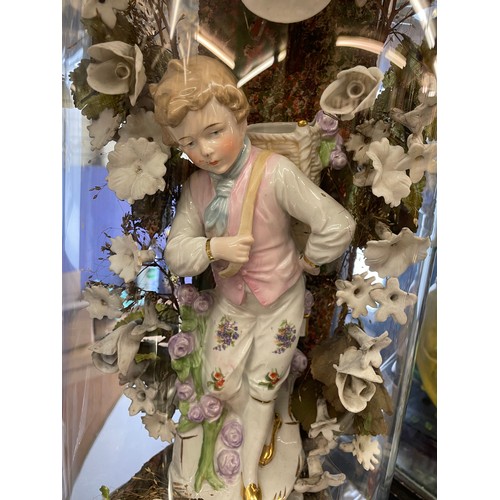 490 - PAIR OF VICTORIAN GERMAN PORCELAIN BOY AND GIRL FIGURE IN FLORAL SETTING UNDER GLASS DOMES