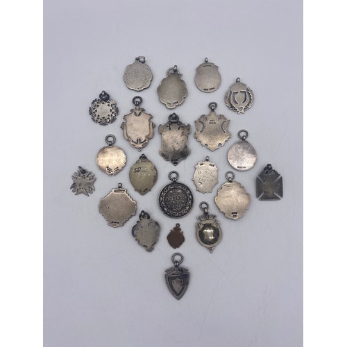 597 - SELECTION OF SILVER AND ENAMEL SHIELD SHAPED AND CIRCULAR MEDALLIONS AND FOBS 6.8OZ APPROX