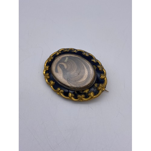 554 - 19TH CENTURY PINCH BECK AND ENAMELLED MOURNING BROOCH WITH HAIR LOCKET