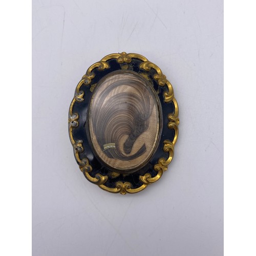 554 - 19TH CENTURY PINCH BECK AND ENAMELLED MOURNING BROOCH WITH HAIR LOCKET