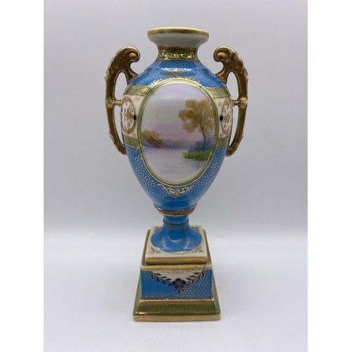 503 - PAIR OF NORITAKE BLUE AND GILT TWIN HANDLED VASES WITH PANELS DEPICTING RIVER SCENE HEIGHT 25.5CM