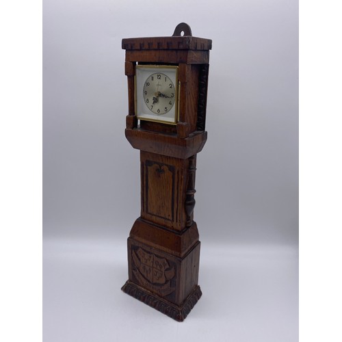 499 - QUARTZ CLOCK IN A CARVED OAK LONG CASE HEIGHT 39CM APPROX