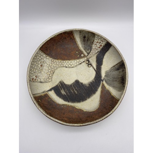 493 - STUDIO POTTERY EARTH TONE ABSTRACT SHALLOW BOWL BY JAN BURNELL DIAMETER 32CM APPROX