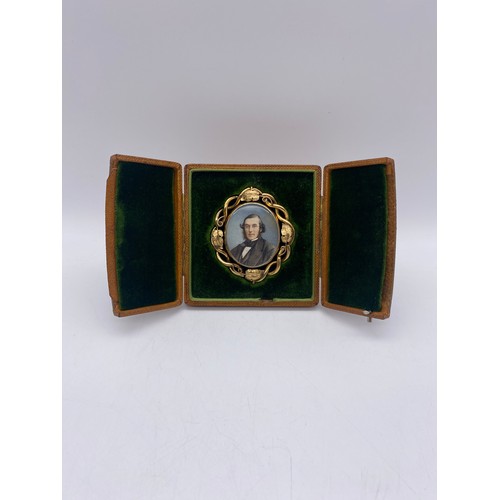 555 - VICTORIAN UNMARKED YELLOW METAL CASED PORTRAIT MINIATURE WITH HAIR LOCKET VERSO HOUSED IN A LEATHER ... 