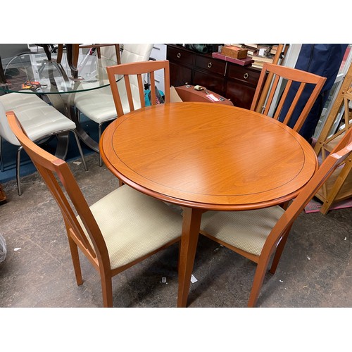 129 - CONTEMPORARY CIRCULAR EXTENDING DINING TABLE AND FOUR CHAIRS