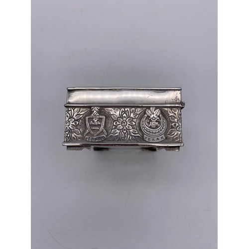 519 - WHITE METAL RECTANGULAR CIGARETTE BOX WITH REPOUSSE DECORATION AND ARMORIAL CREST PRESENTATION INSCR... 