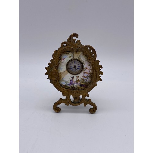 634 - GILT METAL CASED PORCELAIN TIME PIECE IN THE ROCOCO STYLE