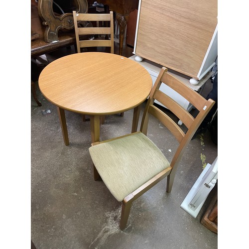 173 - HJ BERRY CIRCULAR OAK TABLE AND PAIR OF UPHOLSTERED DINING CHAIRS