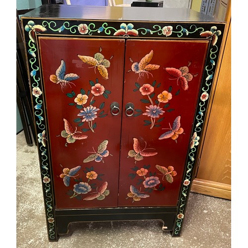 140 - RED LAQUERED AND PAINTED TWO DOOR CHINESE INSPIRED CUPBOARD