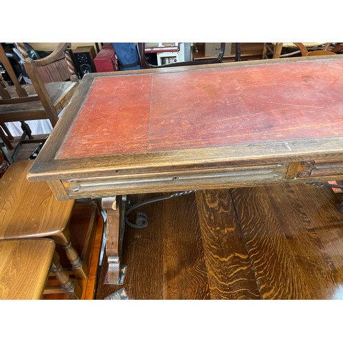 148 - CONTINENTAL OAK LEATHER TOPPED AND WROUGHT IRON WORK TABLE FITTED WITH TWO LINENFOLD DRAWERS