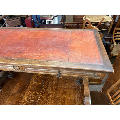 148 - CONTINENTAL OAK LEATHER TOPPED AND WROUGHT IRON WORK TABLE FITTED WITH TWO LINENFOLD DRAWERS