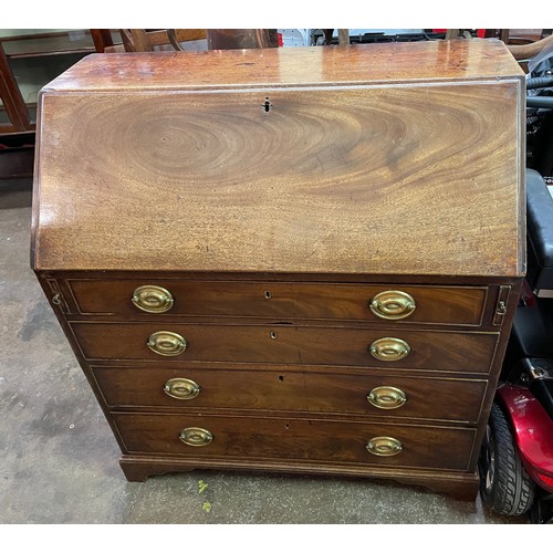 77 - GEORGE III MAHOGANY BUREAU THE FALL FLAP ENCLOSING A FITTED INTERIOR WITH LOPPERS AND FOUR GRADUATED... 