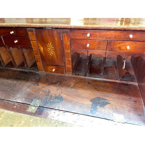 77 - GEORGE III MAHOGANY BUREAU THE FALL FLAP ENCLOSING A FITTED INTERIOR WITH LOPPERS AND FOUR GRADUATED... 