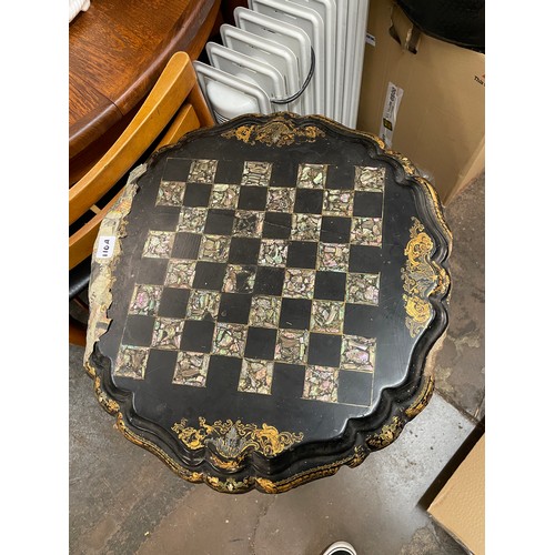 110A - BLACK LACQUERED PAPIER MACHE TILT TOP CHESS TABLE WITH ABALONE BOARD AND GILT BORDER A/F