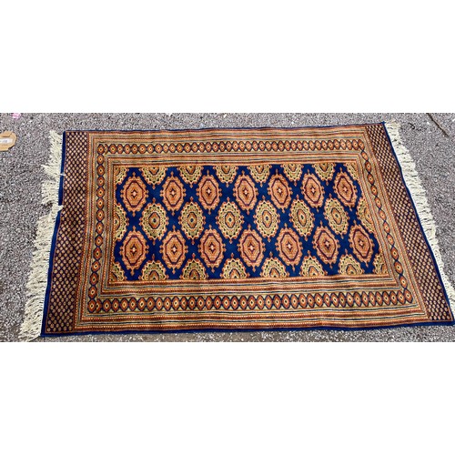 97 - GOOD QUALITY GEOMETRIC PATTERN FRINGED CARPET ON BLUE GROUND 188cm x 120cm