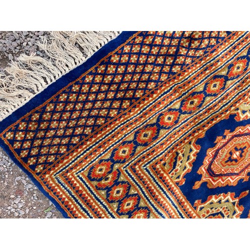 97 - GOOD QUALITY GEOMETRIC PATTERN FRINGED CARPET ON BLUE GROUND 188cm x 120cm