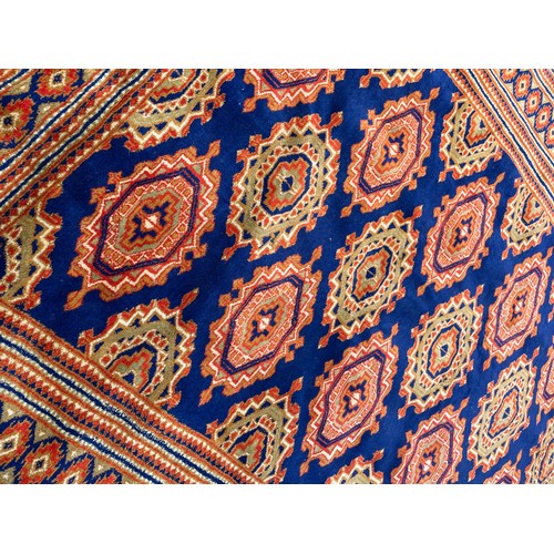 97 - GOOD QUALITY GEOMETRIC PATTERN FRINGED CARPET ON BLUE GROUND 188cm x 120cm